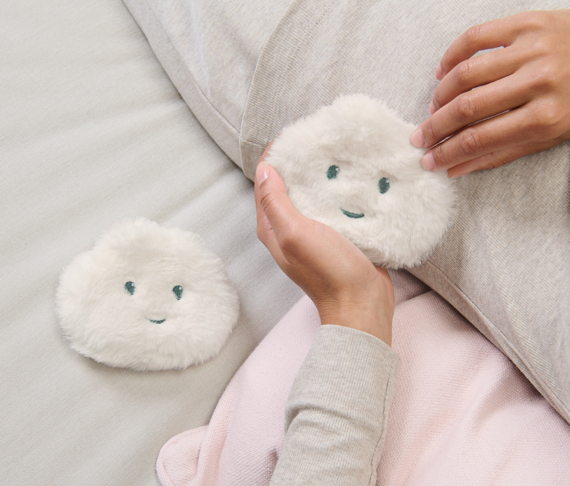 Žena drží v ruce jeden ze dvou hřejivých polštářků do kapsy.