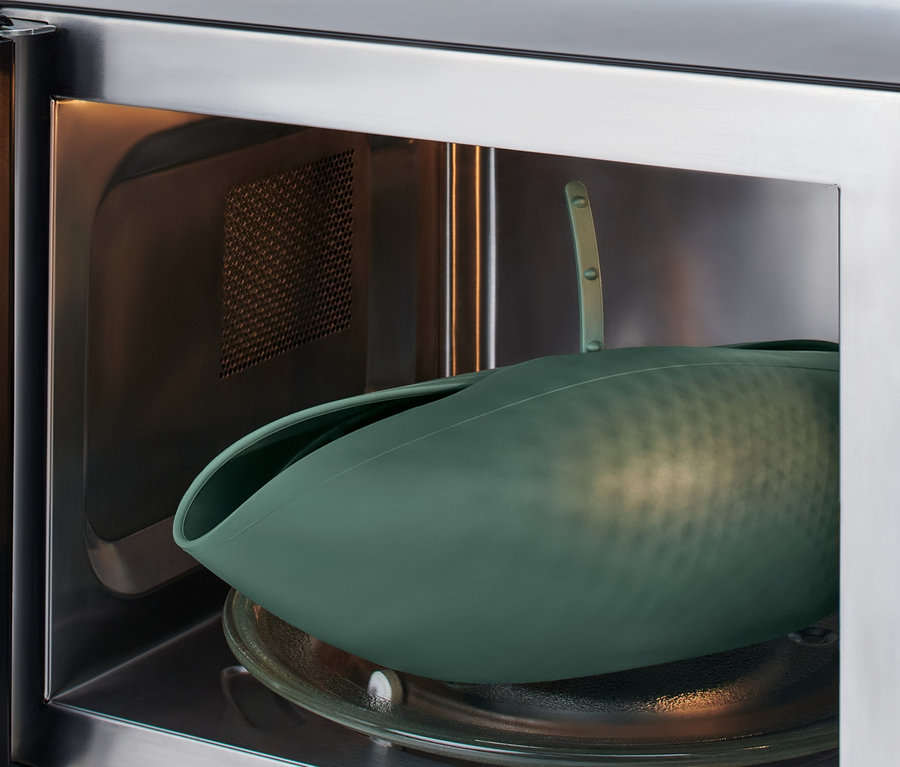 Zelená forma na pečení chleba uvnitř mikrovlnné trouby.