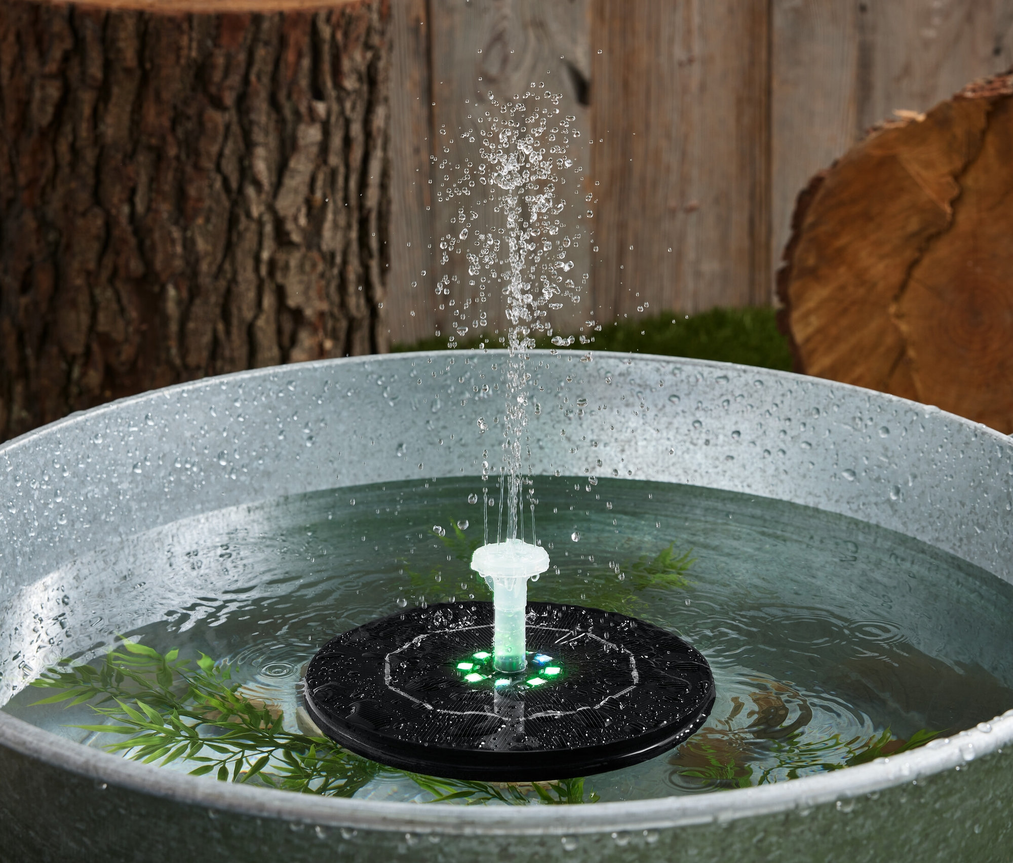 Plovoucí solární fontána s osvětlením ve vaně s vodou.