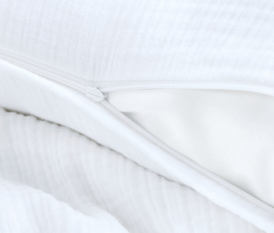 Detail bílého povlečení s rozepnutým zipem.