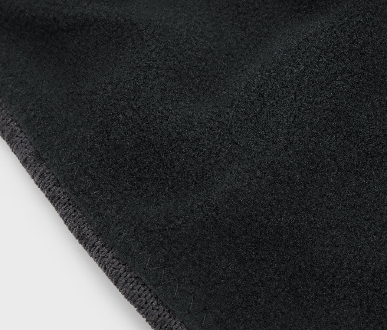 Detailní záběr na černou látku s šedým lemem.