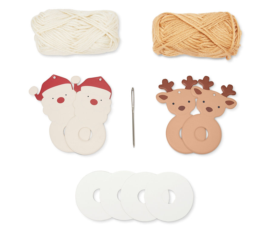 Dva klubka příze, dvě ozdoby Santa Clause, jehla, dvě ozdoby sobů a čtyři bílé kruhy.