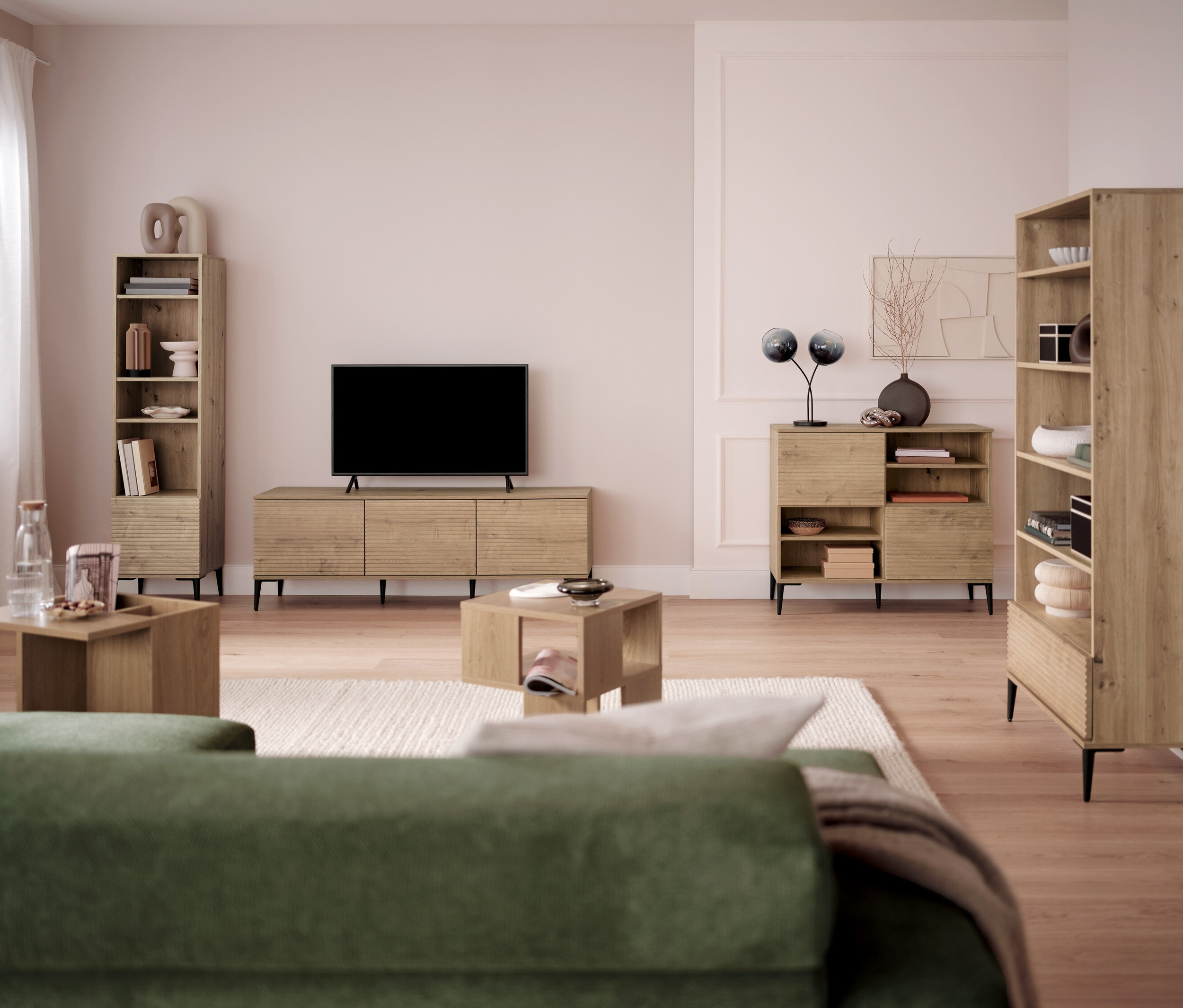 Obývací pokoj s televizí, knihovnami a konferenčními stolky.