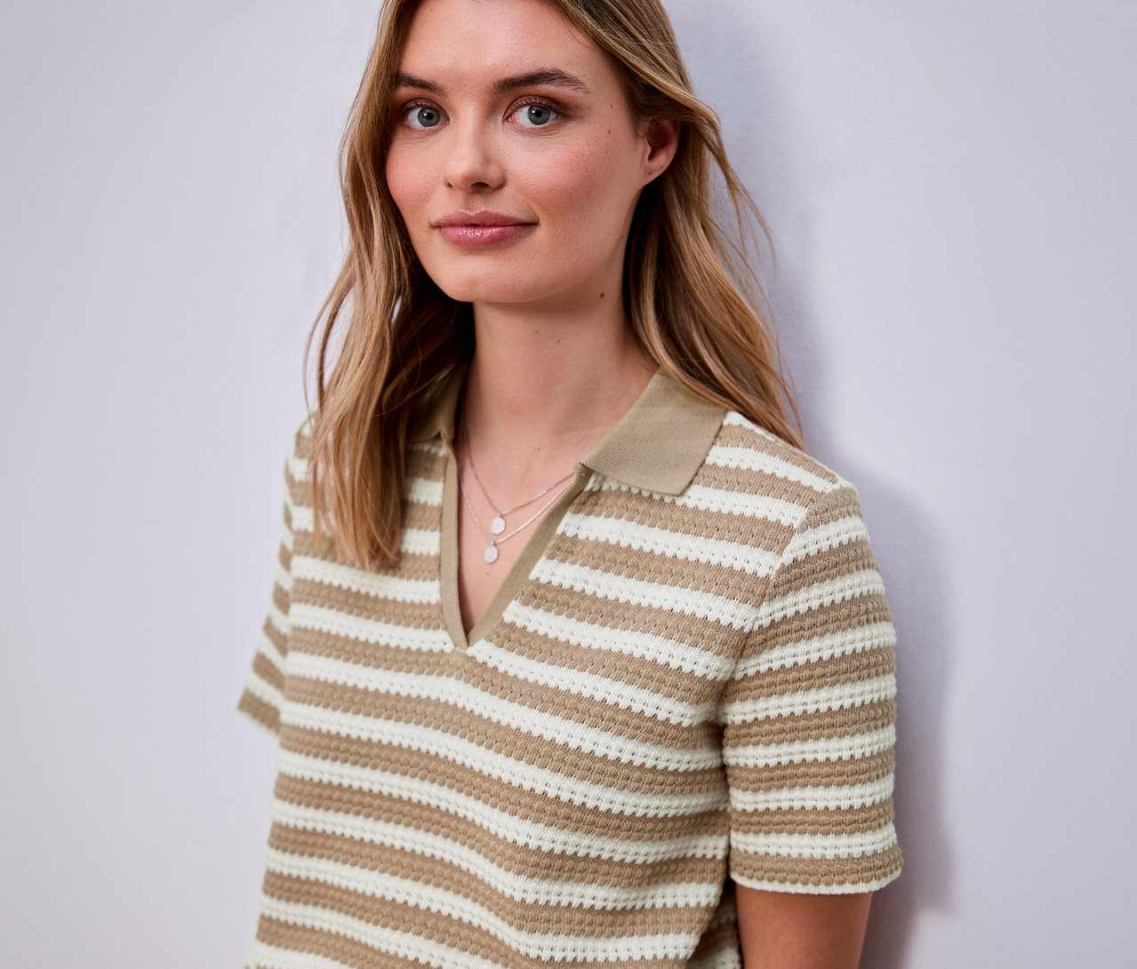 Žena má na sobě proužkované úpletové tričko Street One s krátkým rukávem a límcem.