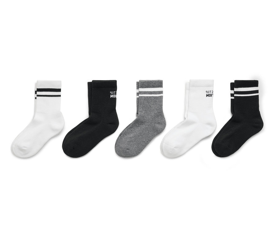 Pět párů ponožek v bílé, černé a šedé barvě seřazených do řady.