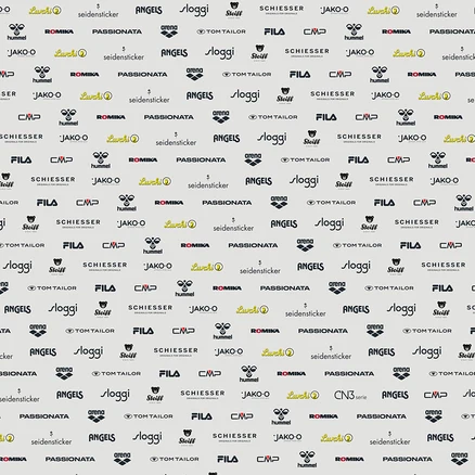 Světlé pozadí s opakujícím se vzorem různých log značek, včetně Lurchi, seidensticker, ANGELS, sloggi, Steiff, SCHIESSER, hummel, ROMIKA, PASSIONATA, arena, TOM TAILOR, FILA, CMP a JAKO-O.