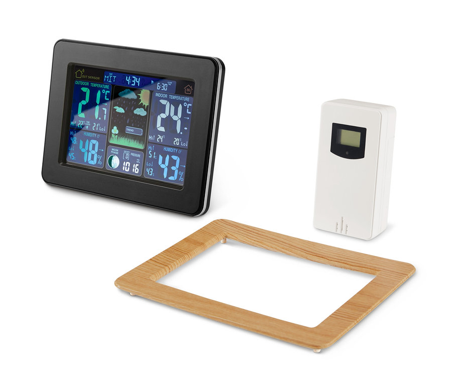 Černá meteorologická stanice s barevným LCD displejem, bílý senzor a dřevěný rám.