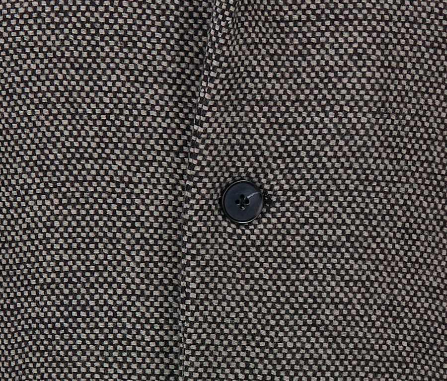 Detail krátkého kabátu s knoflíkem.