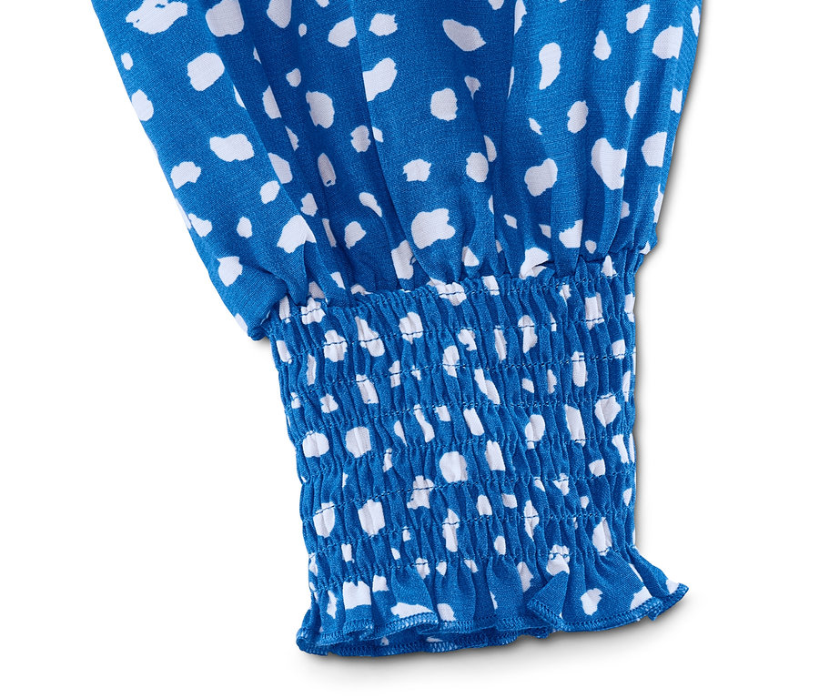 Detail modré halenky s bílým potiskem a elastickým lemem.