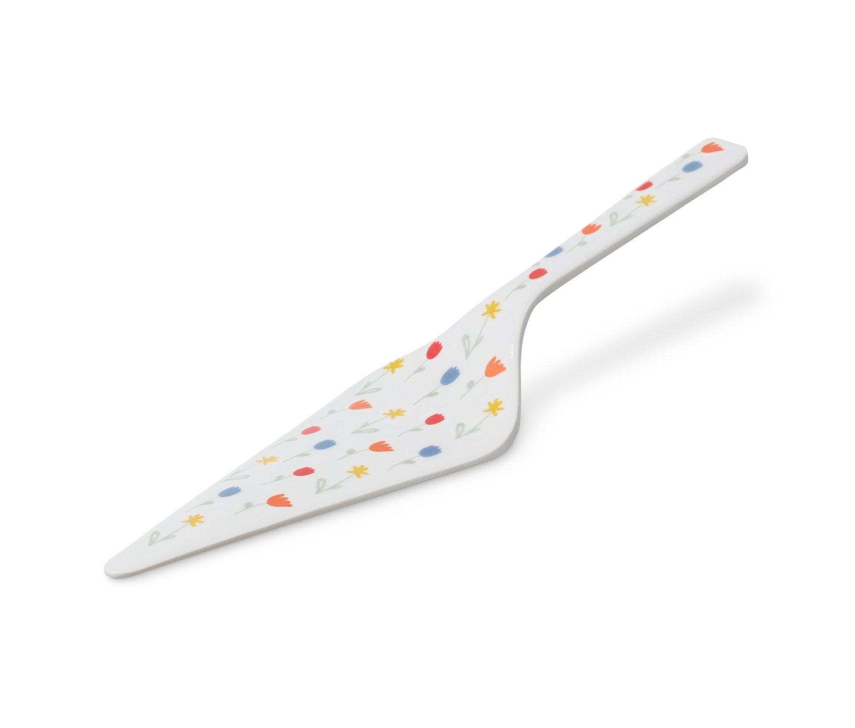 Bílá lopatka na dort s květinovým vzorem.