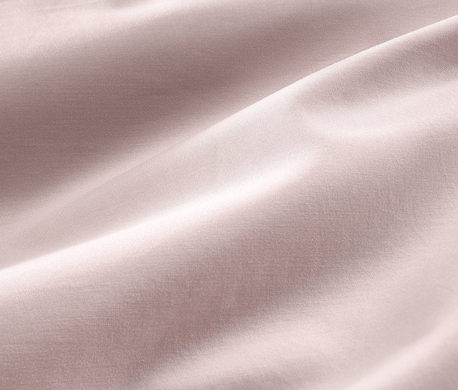 Detailní záběr na růžové bavlněné saténové ložní prádlo standardní a nadměrné velikosti.