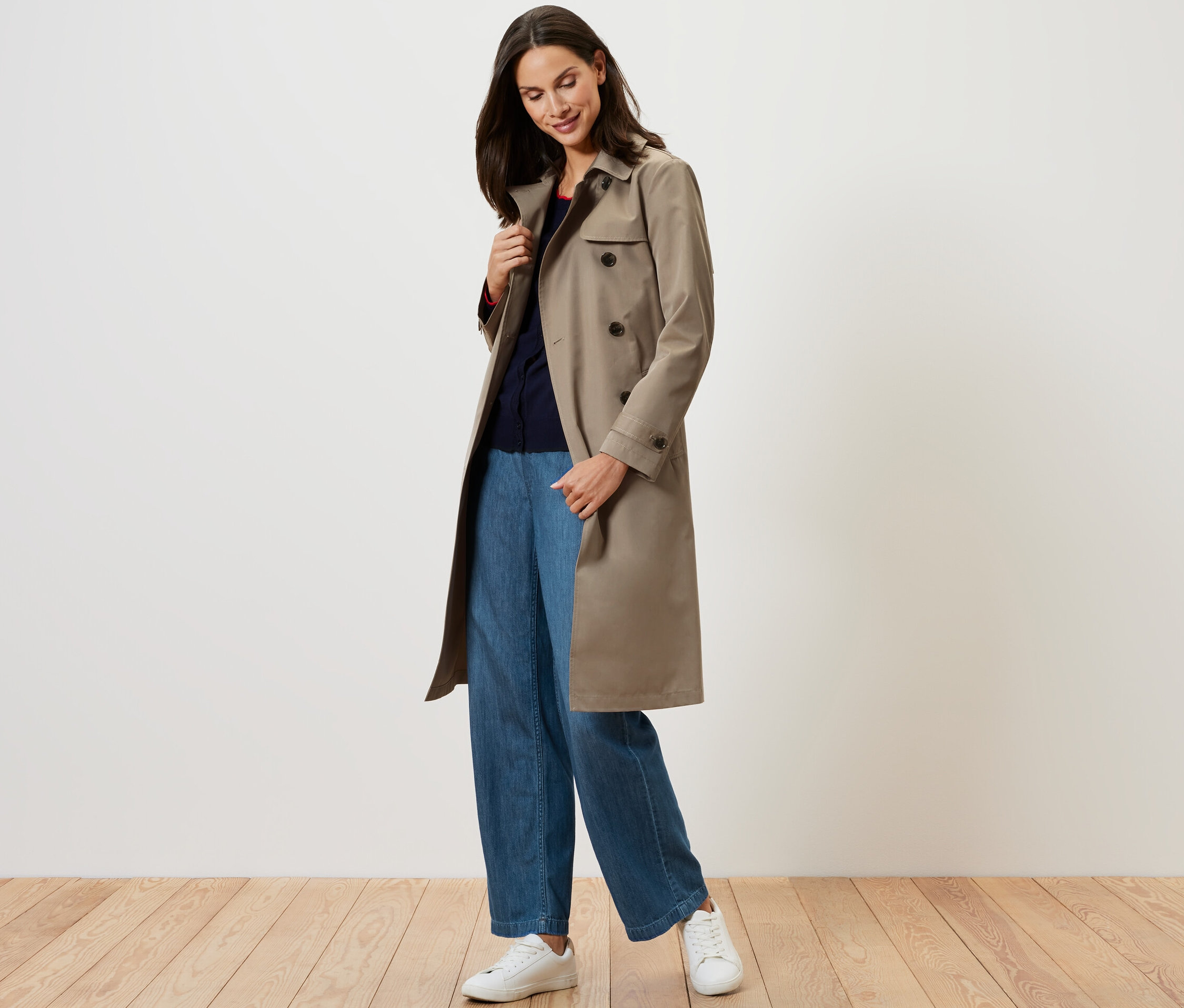 Žena má na sobě béžový trenčkot.