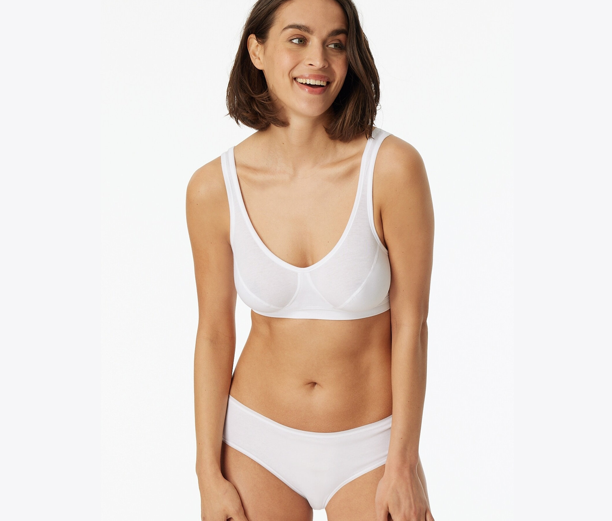 Usmívající se žena má na sobě bílou podprsenku a bokové kalhotky SCHIESSER, 2 ks.