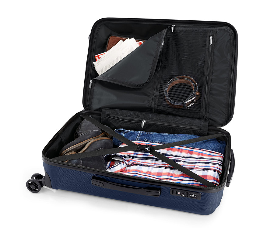 Otevřený kufr z tvrdé skořepiny s oblečením.