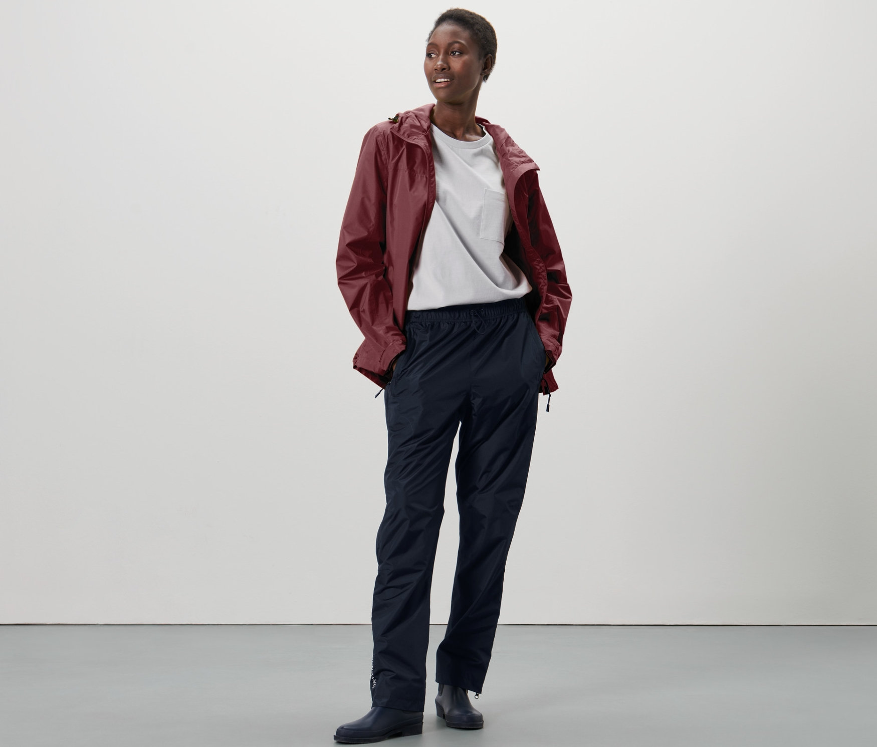 Žena stojí a má na sobě high-tech kalhoty do deště.