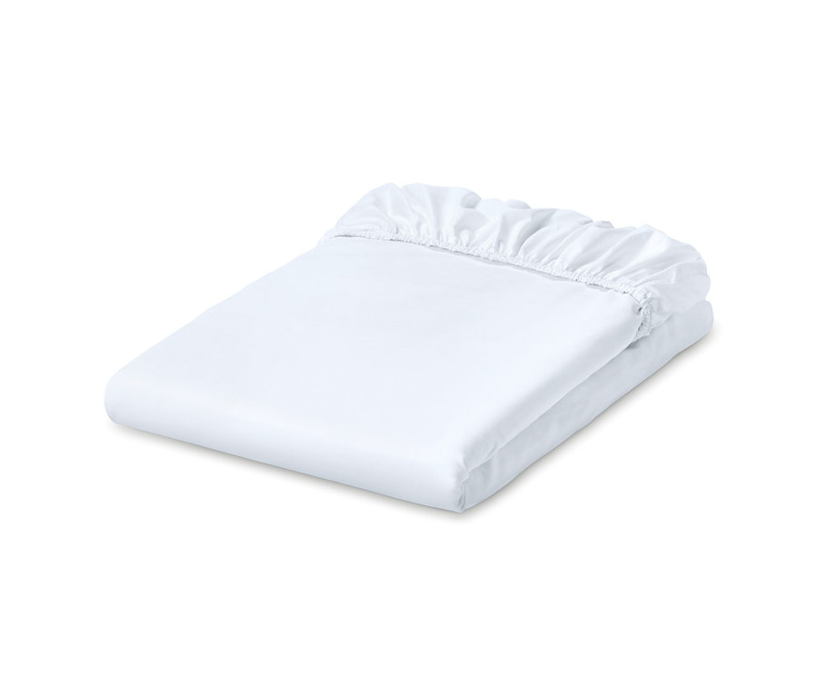 Složené bílé jerseyové napínací prostěradlo.