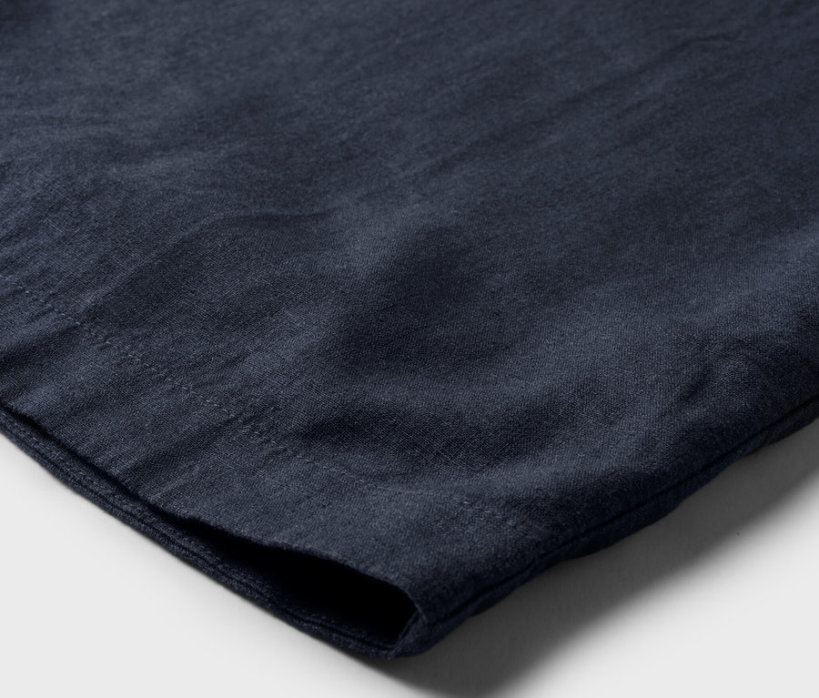 Detail modrých lněných šatů.