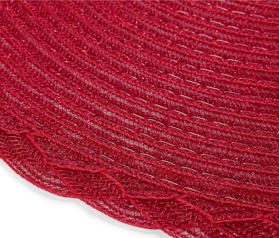 Detail červeného kulatého prostírání z pletené síťoviny.
