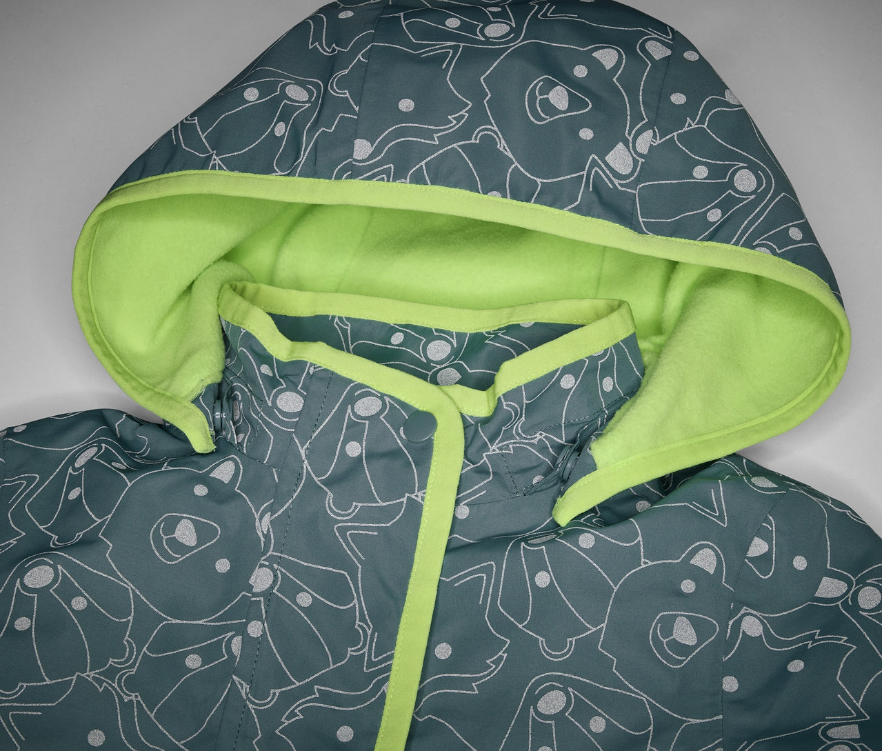 Detail dětské termo bundy do deště s reflexními prvky, s kapucí a potiskem zvířat.