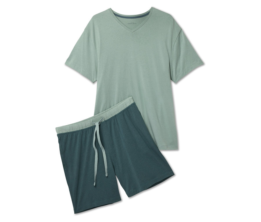 Zelené tričko s krátkým rukávem a modré šortky s tkaničkou leží na bílém pozadí.