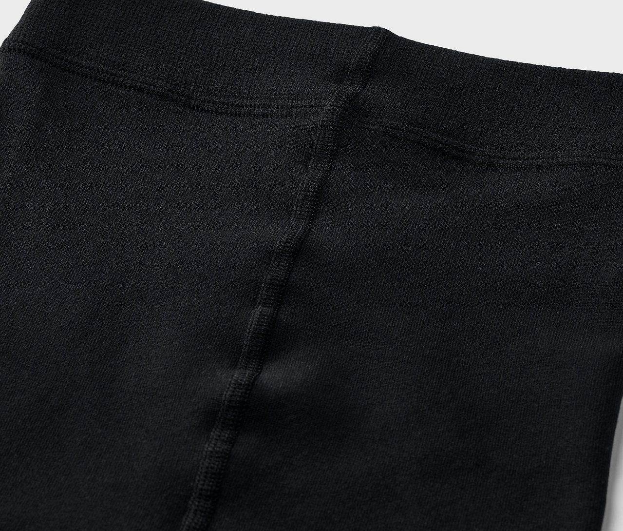 Detailní záběr na pas černých legín.