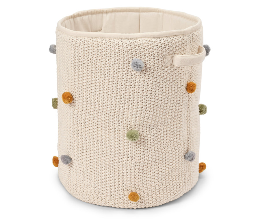 Béžový, kulatý pletený koš s barevnými bambulkami a dvěma držadly.