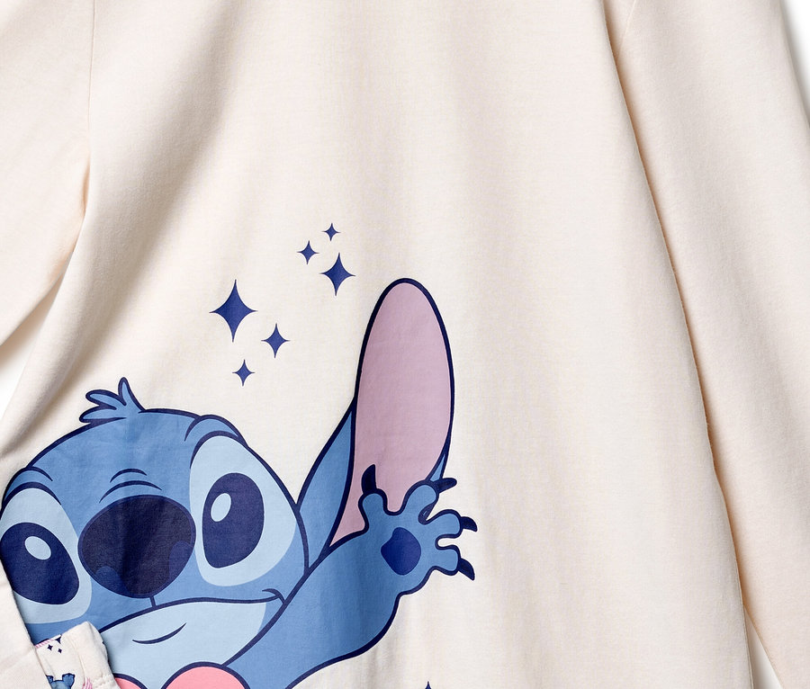 Detailní pohled na krémový top s modrým potiskem Stitch a třpytivými hvězdami.
