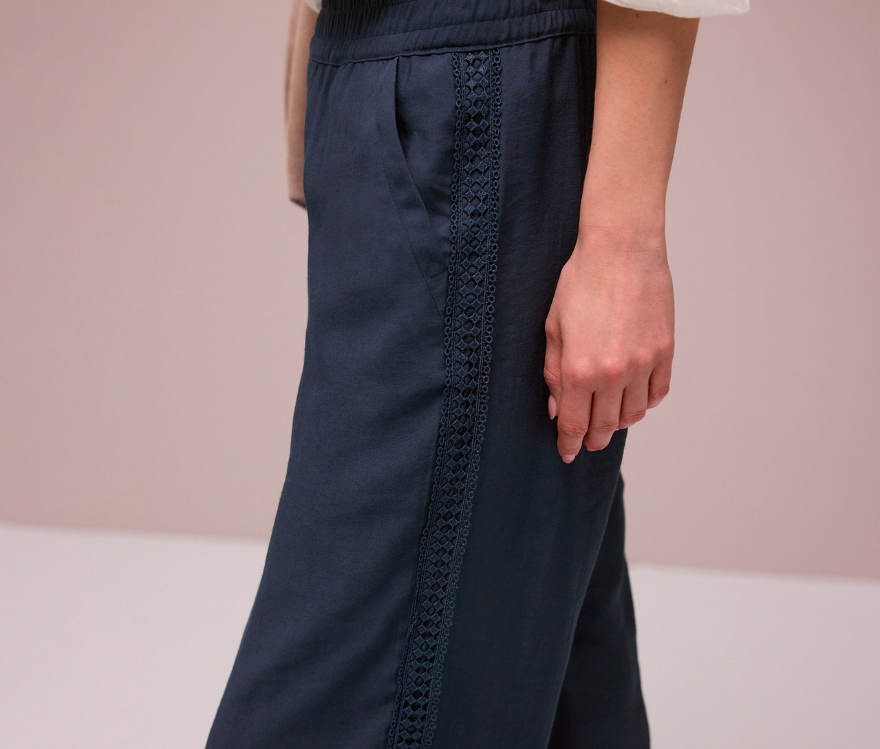 Žena má na sobě tmavě modré kalhoty Street One »Emee« s ozdobnými pruhy.