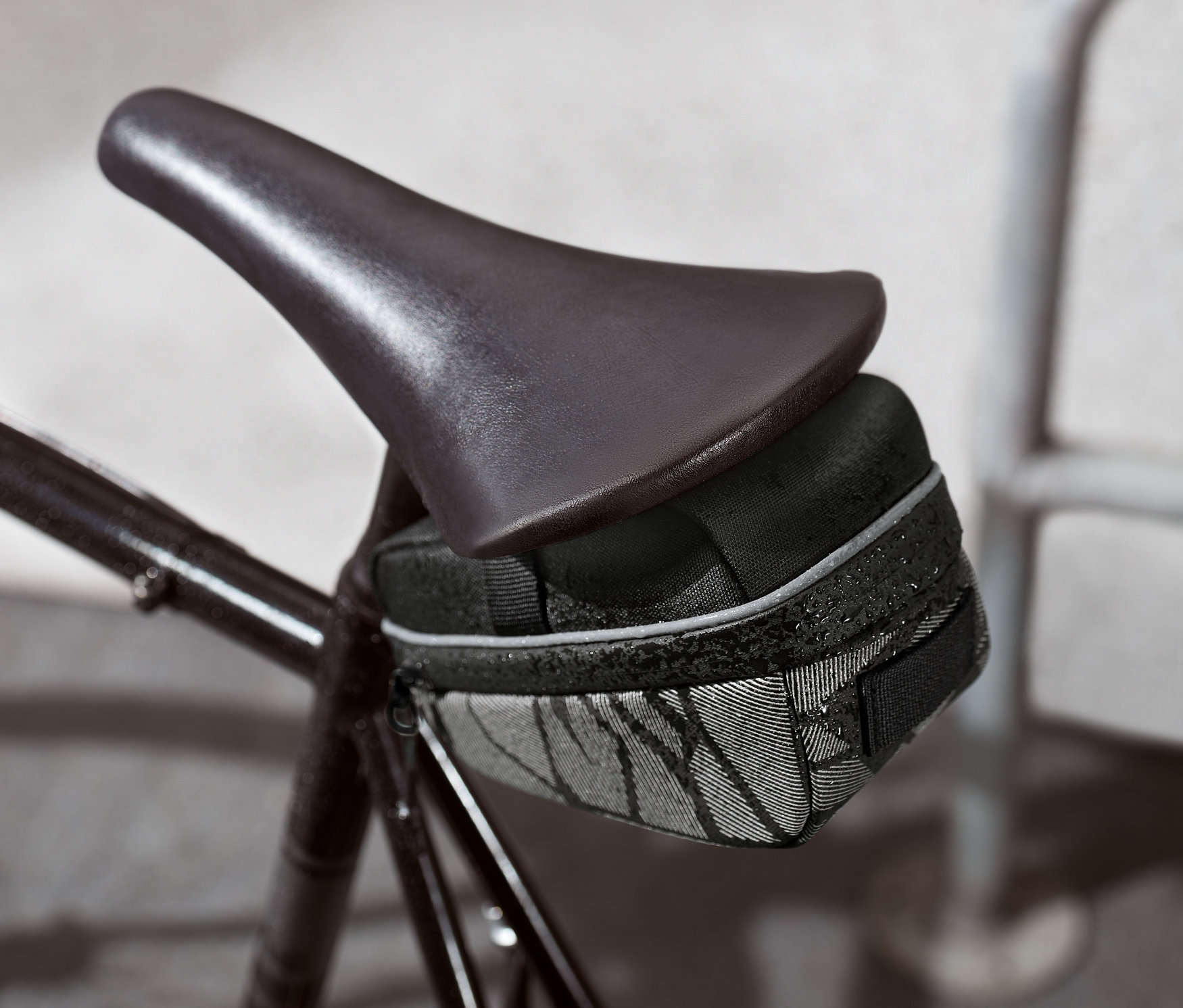 Černá cyklistická brašna pod sedlem na kole.