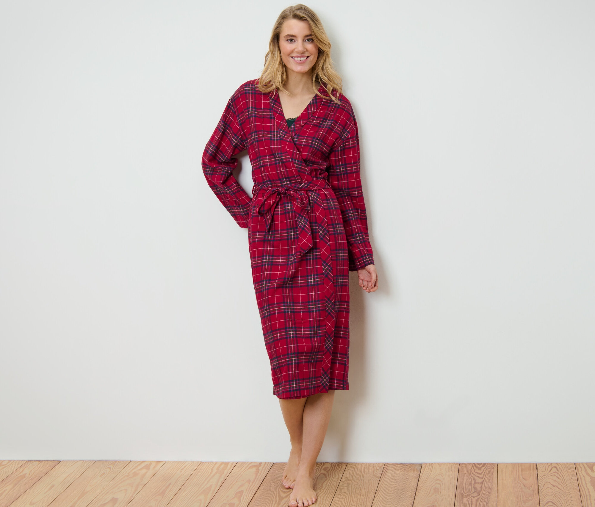 Blondýna stojí a má na sobě červený kostkovaný flanelový župan.