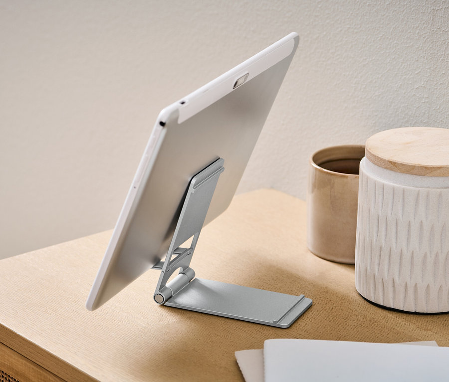 Tablet je umístěn na stojanu na smartphone a tablet.