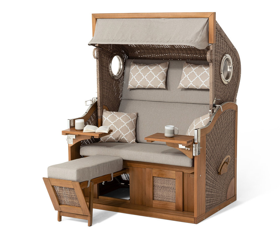 Detailní pohled na plážový koš prémiové kvality XXL se 2 výklopnými stolky. Koš má hnědou proutěnou konstrukci, béžové polštáře a výklopné stolky.