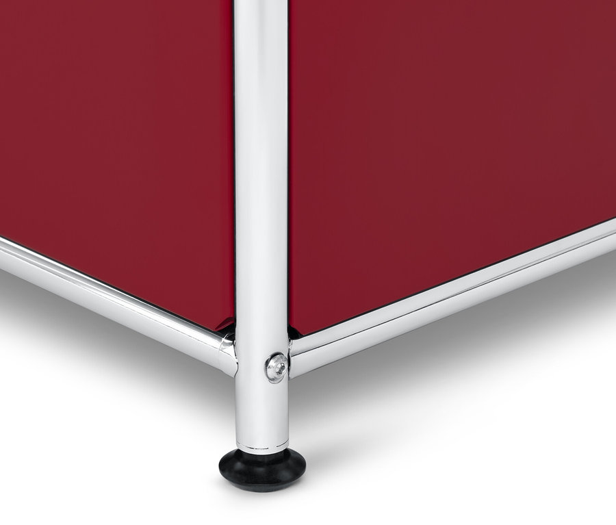 Detail červené odkládací skříňky »CN3« se stříbrným rámem a černými nožičkami.