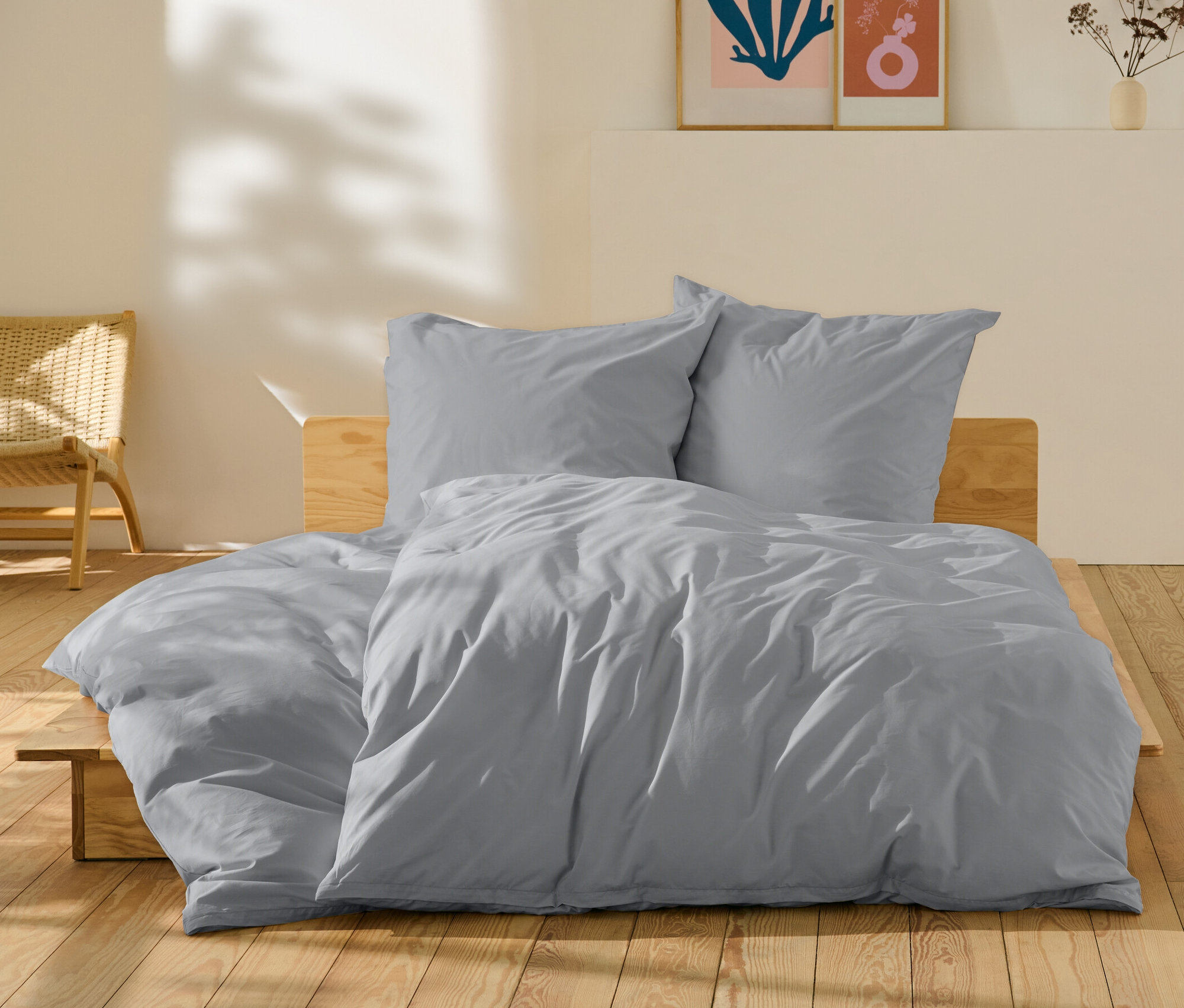 Šedé perkálové povlečení standardní a nadměrné velikosti na posteli.