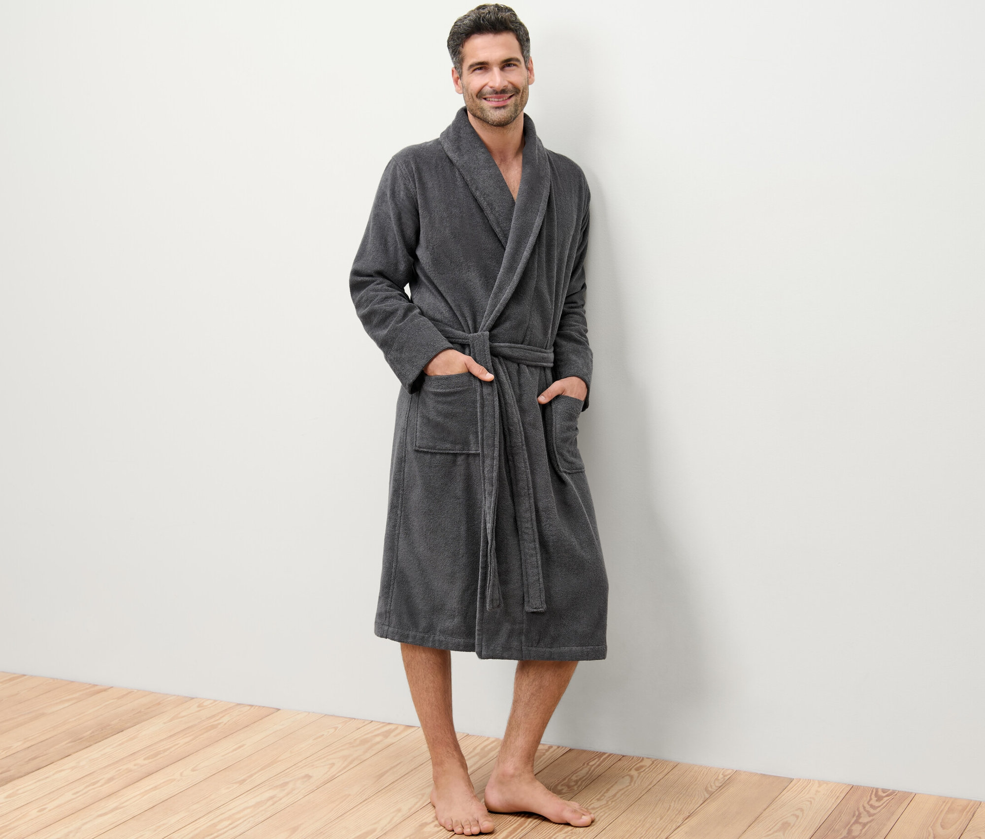 Muž stojí a má na sobě župan.