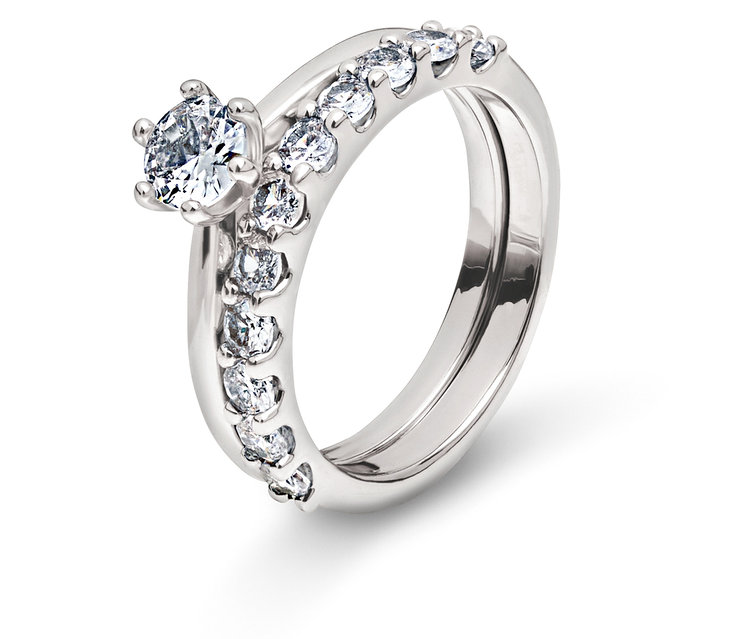 Dva stříbrné prsteny s čirými kameny na bílém pozadí.