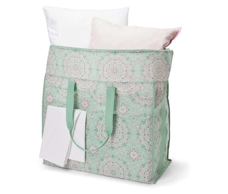 Velká taška na lůžkoviny s bílými a růžovými polštáři.