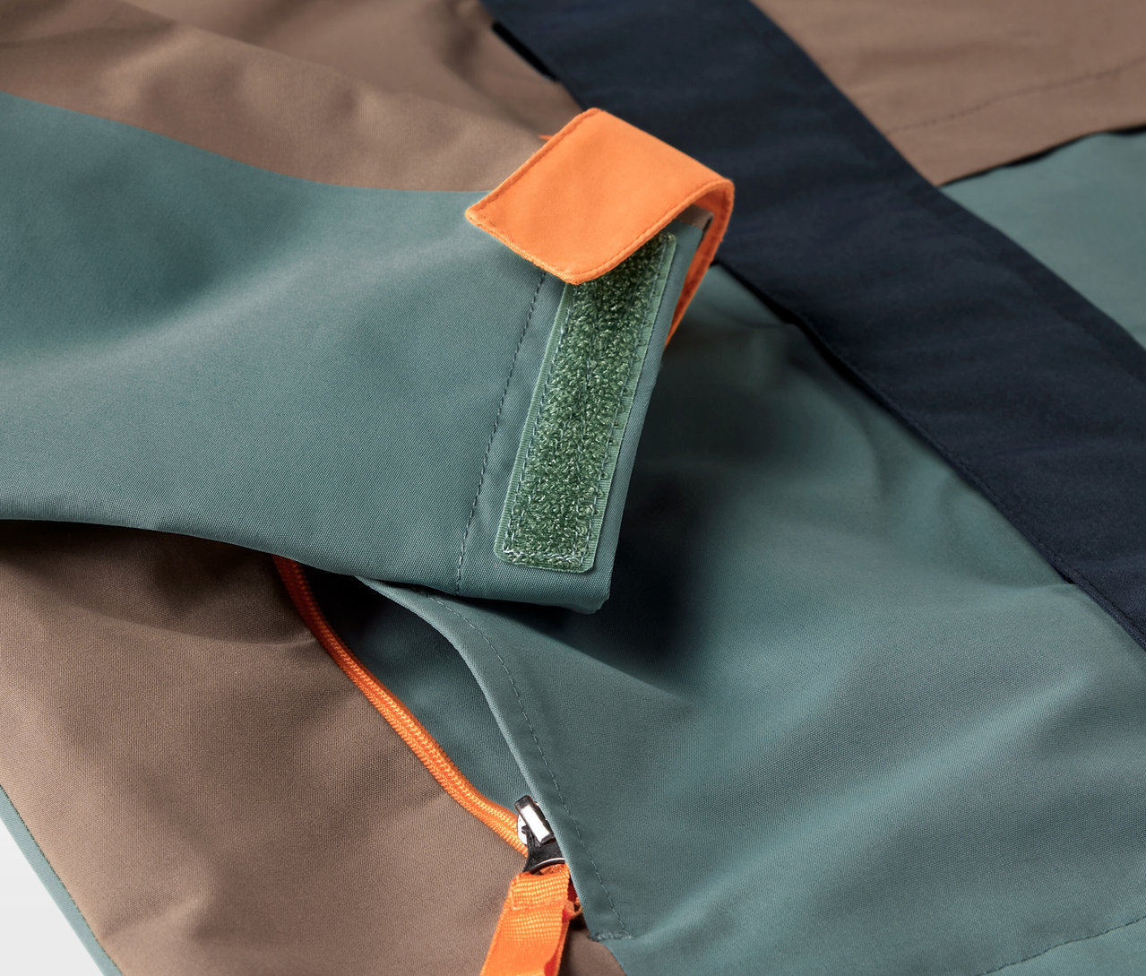 Detail dětské bundy do každého počasí s kapsou na zip a manžetou na suchý zip.