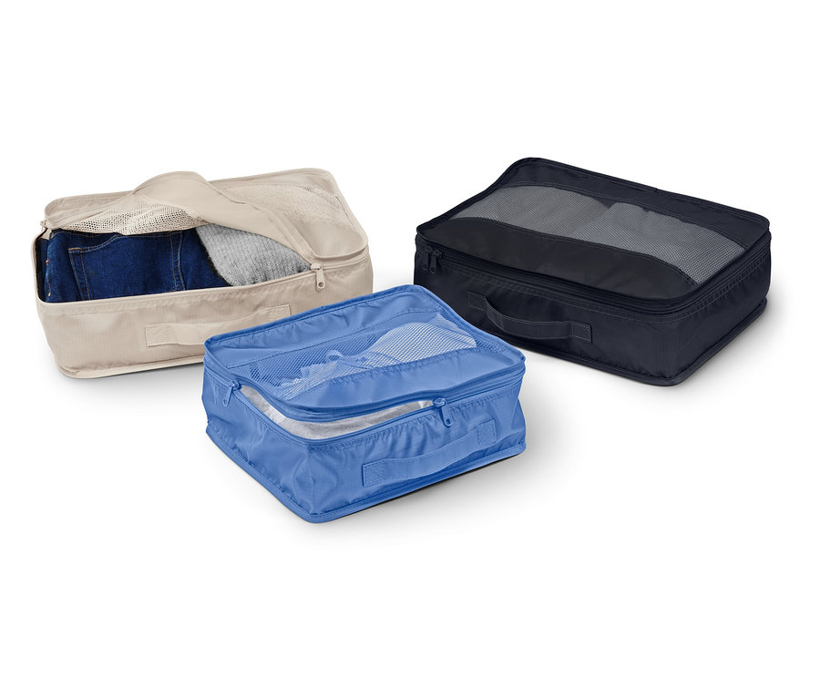 Tři látkové úložné boxy v béžové, modré a černé barvě leží na bílém pozadí.