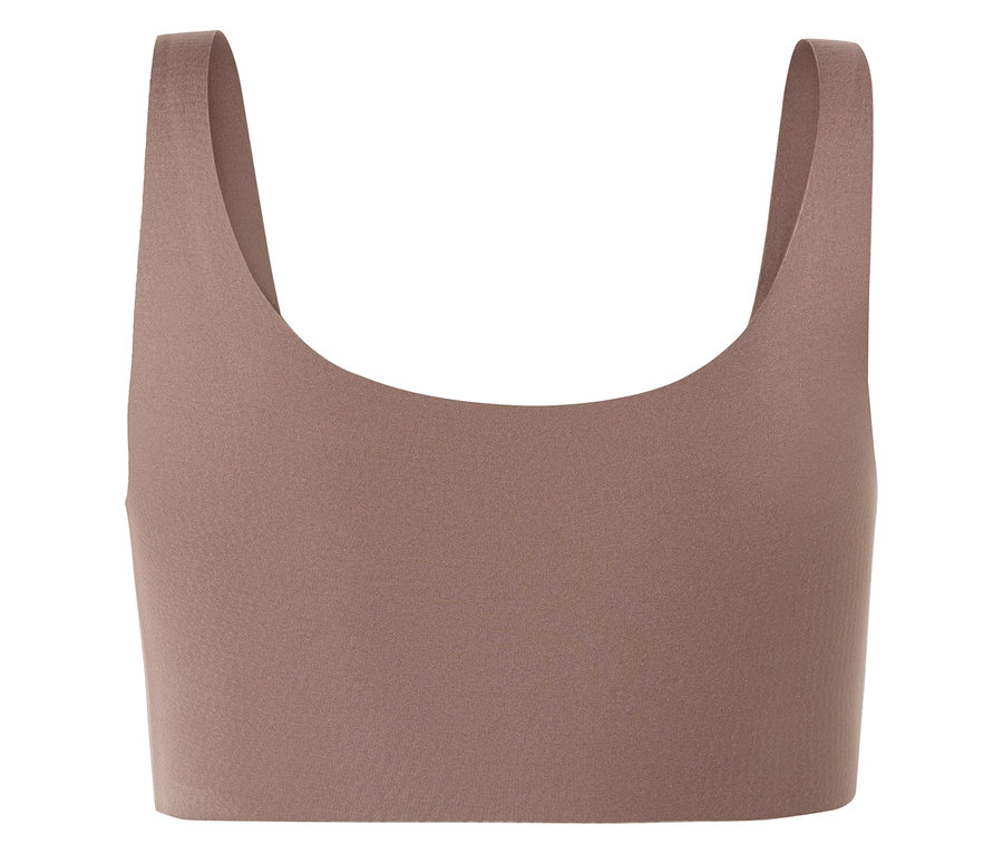 Detailní záběr béžové sportovní podprsenky se širokými ramínky a výstřihem do U.
