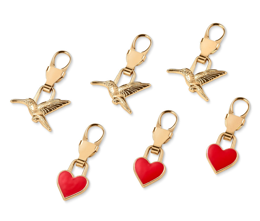 Šest zlatých přívěsků na zip: tři s kolibříky, tři se srdíčky.