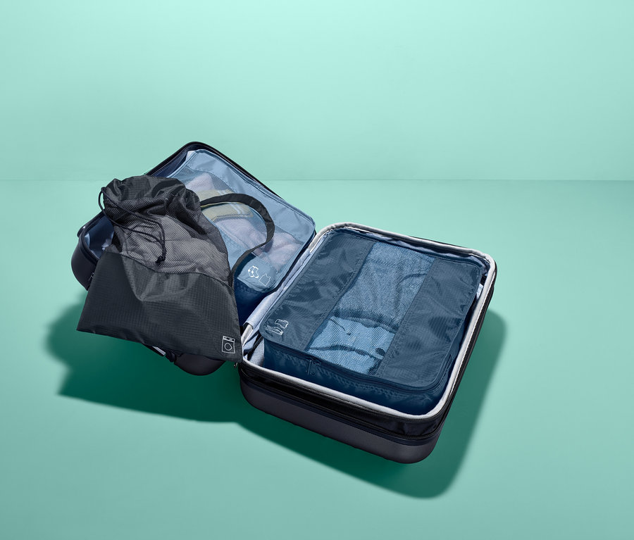 Tři cestovní úložné tašky v kufru.