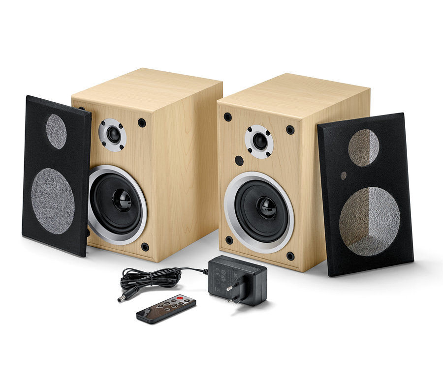 Dva stereo reproduktory s Bluetooth®, napájecí adaptér a dálkové ovládání na bílém pozadí.