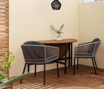 Venkovní terasa s rozkládací pohovkou Elin, dvěma odkládacími stolky Elin, jídelním křeslem s textilním výpletem a sklápěcím stolem Elin.