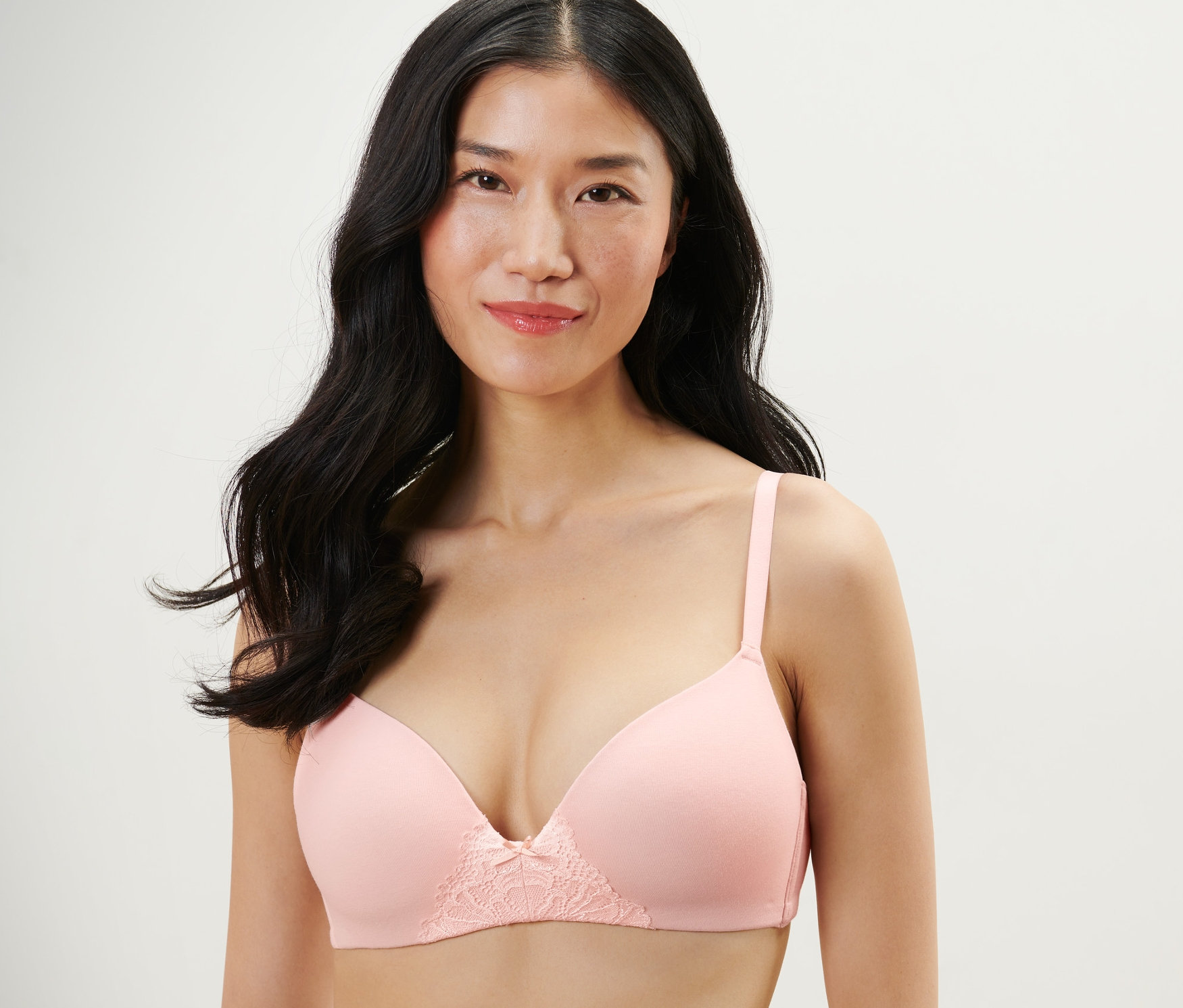 Žena nosí světle růžovou podprsenku s měkkými košíčky.