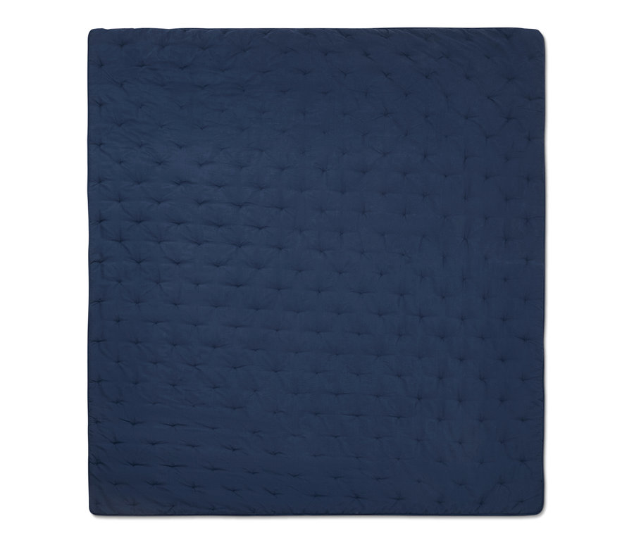 Detailní pohled na modrý přehoz na postel.