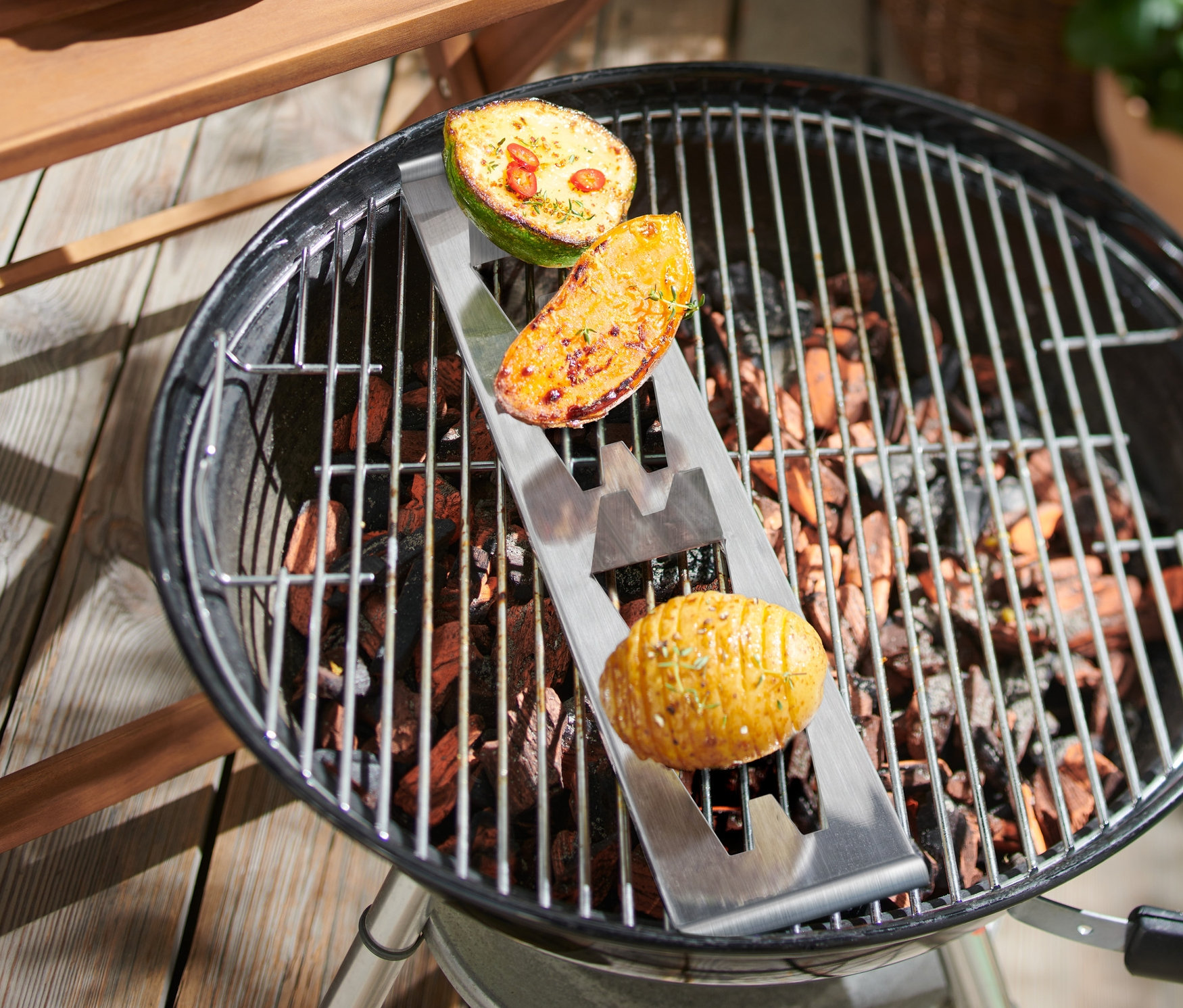 Brambory v držáku na grilu.