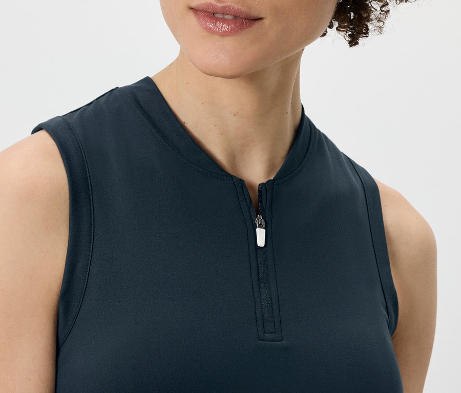 Žena má na sobě tmavě modrý funkční top.