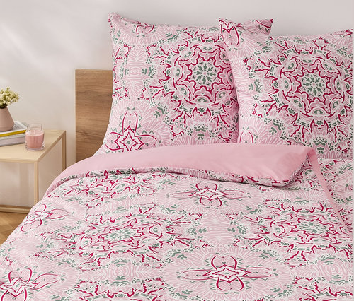 Růžové povlečení z mikrovlákna standardní velikosti s květinovým vzorem na posteli.
