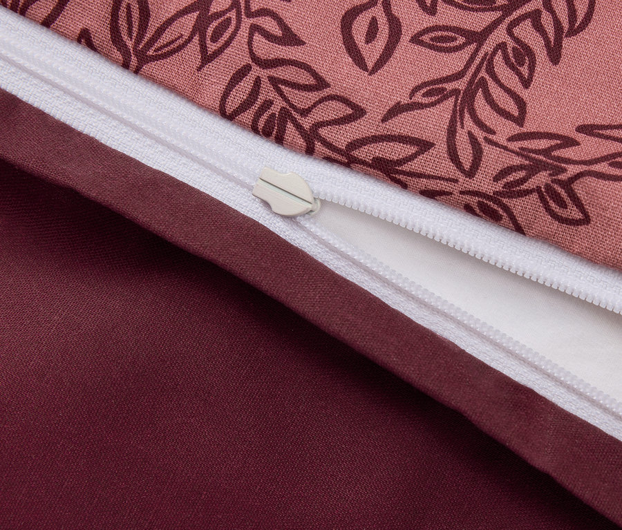 Detailní záběr na povlečení s květinovým vzorem a zipem.